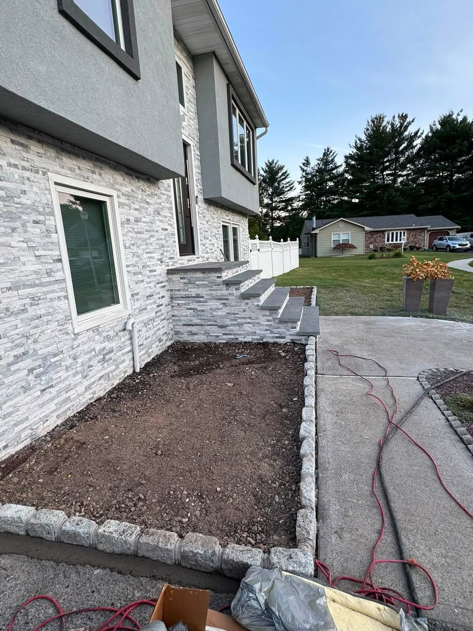 Stone-veneer front entry with new steps and paver edging by ASP1 Construction